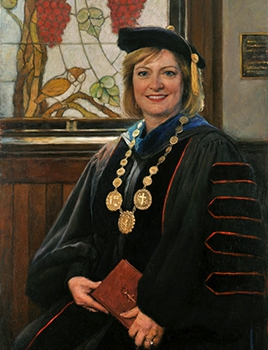 commissioned portrait of woman in academic robes and cap, holding a book.