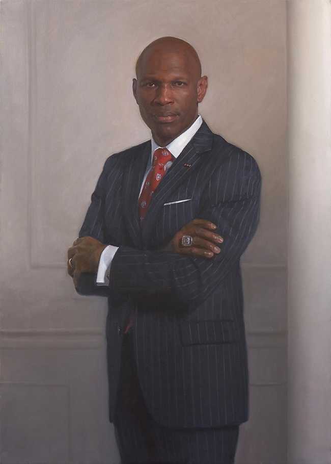 commissioned portrait of a man standing, arms crossed, in a striped suit and tie. 