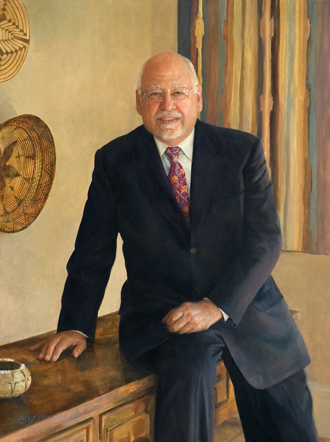 commissioned portrait of older man in suit and tie leaning against desk. 