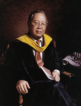 commissioned portrait of man in black and yellow academic regalia sitting down