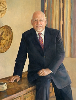 commissioned portrait of older man in suit and tie leaning against desk. 