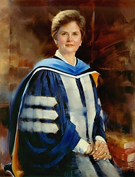 commissioned portrait of short-haired woman, hands crossed over one another, in academic dress. 